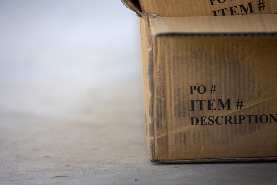 A cardboard shipping box on a concrete floor